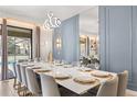 Formal dining room with seating for twelve, modern lighting, and views of the pool area at 1456 Belle Terre Rd, Davenport, FL 33896