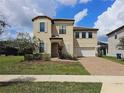 Charming two-story home with a well-manicured lawn and a brick driveway and white window shutters at 191 Aidans Lndg, Haines City, FL 33844