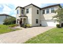 Charming two-story home with a well-manicured lawn and a brick driveway and white window shutters at 191 Aidans Lndg, Haines City, FL 33844