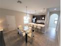Modern eat-in kitchen featuring a large island with white countertops and a dining table with seating at 191 Aidans Lndg, Haines City, FL 33844