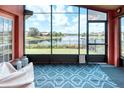 Screened patio with patterned rug and serene lake view through large windows at 233 Rialto Rd, Kissimmee, FL 34759