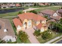 Aerial view of a luxurious home with a red tile roof and a lush green golf course at 2333 Pinehurst Ct, Davenport, FL 33837