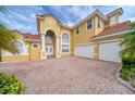 Beautiful two-story home featuring a brick driveway, three-car garage, and arched entryway at 2333 Pinehurst Ct, Davenport, FL 33837