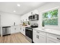 Modern kitchen featuring stainless steel appliances, white cabinetry, and a bright, window-filled space at 304 W 24Th St, Sanford, FL 32771