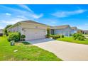 One-story home features a lush green lawn, a spacious driveway, and a well-maintained two-car garage at 3193 Whispering Trails Ave, Winter Haven, FL 33884