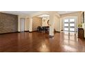 Spacious living room boasts gleaming hardwood floors, designer brick accent wall, and ample natural light at 3759 Eagle Isle Cir, Kissimmee, FL 34746