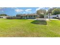 Well-maintained green home featuring a carport and large fenced-in yard, perfect for outdoor activities at 3824 Hickory Tree Rd, St Cloud, FL 34772