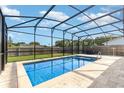 Sparkling in-ground pool surrounded by a screened enclosure and a travertine tile deck at 3824 Hickory Tree Rd, St Cloud, FL 34772