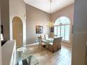 Elegant dining room featuring a glass table with seating for six and a chandelier at 401 Chinahill Ct, Apopka, FL 32712