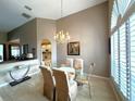 Vaulted ceiling dining area with a view to living room, chandelier, and large windows at 401 Chinahill Ct, Apopka, FL 32712