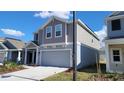 Charming new construction home with a neutral gray exterior and a well-maintained lawn at 443 Cool Summer Ln, Davenport, FL 33837