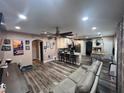 Open-concept living room and kitchen featuring hardwood floors, neutral colors, and modern ceiling fan at 4447 Maple Chase Trl, Kissimmee, FL 34758