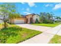 Beautiful home showcasing a well-kept lawn, long driveway, attached garage, and decorative palms for added curb appeal at 4720 Doral Pointe Dr, Kissimmee, FL 34758