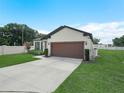 Charming single story home featuring a well-manicured lawn, landscape, and a two-car garage at 5473 Animosh Ct, Polk City, FL 33868