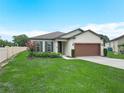 Charming single story home featuring a well-manicured lawn, landscape, and a two-car garage at 5473 Animosh Ct, Polk City, FL 33868