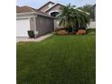 Charming home featuring a manicured front yard with a lovely garden and a two-car garage at 5921 Lake Champlain Dr, Orlando, FL 32829