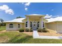 Inviting one-story home featuring a lush lawn, well-maintained landscaping, and a covered entryway at 6555 Bay Tree Ct, St Cloud, FL 34771