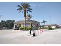 Community entrance gatehouse with palm trees, attractive landscaping and marked entry lanes for visitors at 8101 Coconut Palm Way # 303, Kissimmee, FL 34747