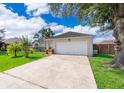 Exterior view of a home featuring a two-car garage and a long concrete driveway at 812 Adour Dr, Kissimmee, FL 34759