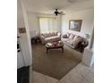 Inviting living room with plush sofas, a ceiling fan, and natural light from the window at 939 Jaybee Ave, Davenport, FL 33897