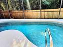 Sparkling blue pool with a safety rail and screened-in enclosure for year-round enjoyment at 1006 Soaring Eagle Ln, Kissimmee, FL 34746