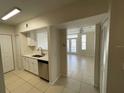 Open concept kitchen with white cabinets and stainless steel appliances that flows seamlessly into the living area at 1020 Siena Park W Blvd # 304, Kissimmee, FL 34747