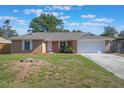 Charming one-story brick home with a well-manicured lawn, a two car garage, and fresh landscaping at 1022 Blue Horizon Dr, Deltona, FL 32725