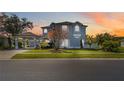 Beautiful two-story home featuring a porte-cochere, lush landscaping, and classic architectural details at sunset at 12134 Shadowbrook Ln, Orlando, FL 32828