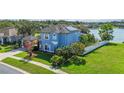 Picturesque two-story lakefront home with solar panels, mature landscaping, and covered side-entry garage at 12134 Shadowbrook Ln, Orlando, FL 32828