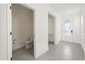Bright foyer with gray tile flooring and a conveniently located half bathroom at 1765 Petiole Pl, Kissimmee, FL 34744