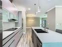 Modern kitchen with sleek cabinetry, stainless steel appliances, and a spacious island with a sink at 2000 Greenbriar Ter, Davenport, FL 33837