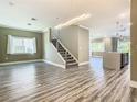 Bright, open-concept living space with wood floors and a modern staircase leading to the second floor at 2000 Greenbriar Ter, Davenport, FL 33837
