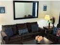 Comfortable living room featuring a large mirror, modern decor, and cozy seating arrangement at 2514 Dharma Cir, Kissimmee, FL 34746