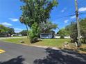 Property featuring a cozy home with a well-maintained lawn and mature trees at 2704 Sample St, Kissimmee, FL 34744