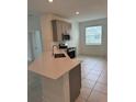 Cozy kitchen featuring stainless steel appliances, gray cabinets, tiled floor and eat in area at 4053 Redbridge Loop, Davenport, FL 33837