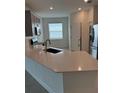 Open concept kitchen featuring stainless steel appliances, gray cabinets, and white countertops at 4053 Redbridge Loop, Davenport, FL 33837