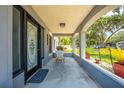Cozy front porch, featuring decorative columns, a welcoming chair, and intricate door design at 435 Pennsylvania Ave, St Cloud, FL 34769