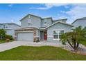 Charming two-story home with a stone-accented facade, well-maintained lawn and inviting red front door at 454 Hamlet Loop, Davenport, FL 33837