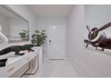 Modern entryway with white console, artistic mirror, striking airplane art, and sleek marble tile floors at 454 Hamlet Loop, Davenport, FL 33837