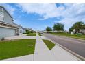Neighborhood street with sidewalks, manicured lawns, palm trees, and visible homes at 454 Hamlet Loop, Davenport, FL 33837
