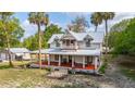 Charming two-story home with a large front porch, showcasing the home's curb appeal and welcoming entrance at 525 W Blue Springs Ave, Orange City, FL 32763