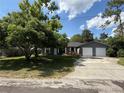 Charming single-story home with a two-car garage, gray siding, stone accents, and a well-maintained lawn at 6489 Creation St, St Cloud, FL 34771