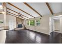 Inviting living room with dark hardwood floors, exposed beams, and a stone fireplace at 710 Carlton Ave, Lake Wales, FL 33853