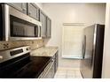 Close-up on stainless steel appliances in the kitchen with granite countertops at 8517 Bay Lilly Loop, Kissimmee, FL 34747