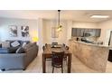 Open-concept living area featuring a dining table, view of kitchen and comfortable seating at 8517 Bay Lilly Loop, Kissimmee, FL 34747