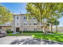 Condo building featuring well-maintained landscaping, trees, and assigned parking at 1231 Wright Cir # 1213, Celebration, FL 34747