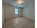 Bedroom featuring tiled floors, a window, and a closet at 127 Alabama Ave, St Cloud, FL 34769
