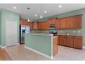Bright kitchen with stainless steel appliances, wood cabinets, and granite countertops at 1394 Palmetto Dunes St, Champions Gate, FL 33896
