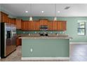 Bright kitchen with stainless steel appliances, wood cabinets, and granite countertops at 1394 Palmetto Dunes St, Champions Gate, FL 33896