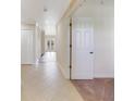 Tiled hallway leading to a carpeted bedroom, with a doorway on the right at 1501 Northern Harrier Way # 202, Reunion, FL 34747